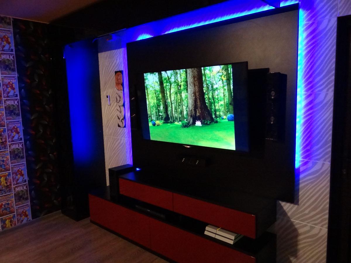 Meble koloru czerwono-czarnego wokół telewizora z neonowymi lampkami